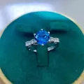 Detailed close-up of a 2ct blue sapphire style ring in a dark green velvet jewelry box - A7 Open Type / Blue