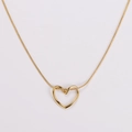 Macro shot of gold-tone hollow heart pendant on a smooth metallic snake chain - Gold