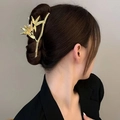 Close-up of golden bamboo leaf hair claw with pearl detail on a woman's bun hairstyle - Gold Emerald Bamboo Hair Clip