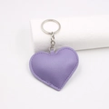 Llavero de cuero violeta con forma de corazón sobre fondo blanco minimalista - Púrpura Taro