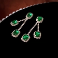 Macro shot of emerald green earrings with shimmering silver tassels and inlaid diamonds - 925 Silver Pin Green Rhinestone Square Tassel Earrings