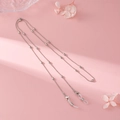 Silver metal eyewear chain with clear silicone loops shown on a stylish floral background - Style 02 / Silver