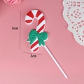 Detail of candy cane cake topper with green bow and dimensions of 6cm height by 3cm width - Candy Cane with Bow