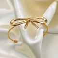 Polished 18K gold butterfly bow open bangle on soft cream satin fabric background - Bowknot Bracelet-Gold