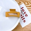 Matte yellow square hollow hair claw clip for women on a ceramic decorative plate - Turmeric