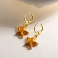 Primer plano de pendientes de estrella de mar bañados en oro con esmalte naranja - Naranja