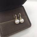 Dettaglio di orecchini di perle con ganci dorati in una scatola per gioielli di velluto marrone - 7.5mm Base Oro Perla Tonda Tacco Alto in Argento