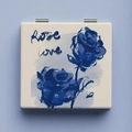 Close-up of square mini makeup mirror featuring blue rose pattern and Rose Love text - Rose Love
