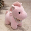 Pink plush horse toy with purple floral scarf on soft beige carpet background - Pink