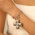 Macro detail of silver metal bracelet featuring textured cross pendant on model wrist - Silver Bracelet (Snail Texture 12032)