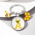 Detalle del llavero de abeja con perla, colgante de panal y cúpula de vidrio letra A - Letra A