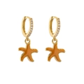 Detailed close-up of gold starfish drop earrings with zircon inlay and orange glaze - Orange Starfish