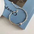 Minimalist silver heart tag beaded bracelet with adjustable chain on blue magazine - Heart Charm Silver Bracelet
