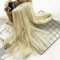 Crease-textured silk scarf in cream beige draped elegantly over a black metal rack - 190cmx75cm / Off White