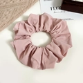Macro view showing the smooth texture and layered folds of the large pink satin scrunchie - Pink