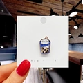 Detail of cute blue cartoon milk tea enamel pin badge on a paper card held by hand - 134*Pearl Milk Tea Pin