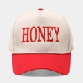 Primer plano del bordado 3D HONEY en una gorra trucker beige y roja con costuras firmes - Ajustable / Rojo Beige