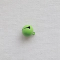 Detail shot of a 14mm bright green painted metal bell with hanging loop on white fabric - Green