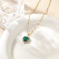 Macro detail of heart-shaped green crystal pendant with pavé cubic zirconia on gold chain - Emerald Green Pendant Necklace