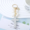 Elegante portachiavi dorato con perle bianche e pendente a croce in strass lucidi - Bianco
