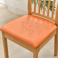 Waterproof orange PU leather chair seat cover showing water droplets on wooden chair - Orange