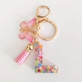 Pink resin letter L keychain with heart sequins, colorful tassel and butterfly charm - Letter L
