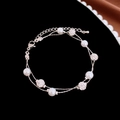 Detail of double-layer silver bracelet with white pearls and pave crystal spheres on black velvet - Double Layer Pearl Bracelet
