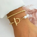 Detail of layered gold beaded bracelet with pearl accents and oversized T-bar toggle clasp - Gold Pearl Layered Style