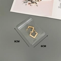 Close-up of golden geometric earrings in 8x6cm transparent PVC self-sealing jewelry pouch - 50 Silk 6x8cm