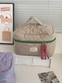 Detail of quilted plaid cosmetic bag featuring green zipper and pink woven rope puller - Makeup Bag / Green