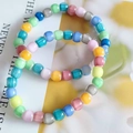 Macro shot of 8mm colorful cat-eye stone beaded bracelets on white paper - Millefiori Glass Barrel Bead