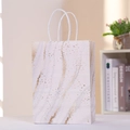 Nahaufnahme der Marmor-Geschenktüte mit goldener Maserung und weißem Baumwollgriff - 21x15x8cm / Weißes Marmormuster