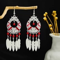 Bohemian silver earrings with red beads and leaf fringe on a natural wood stand - Red