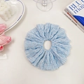 Übergroßes blau-weiß gestreiftes Stoff-Haargummi auf einem dekorativen Tisch - Himmelblau (Gestreift)