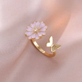 Detail view of a gold open ring with purple daisy and butterfly on silk background - Rotating Flower Ring / Gold