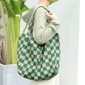 Deep green and beige checkerboard canvas shoulder bag shown on a model for a retro aesthetic - Green