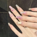Macro detail of ballerina nails with purple flowers, pearls and shimmering diamonds - Medium Coffin - Size XS
