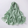 Detail of light green chiffon hijab featuring elegant hand-set crystal flower embellishments - Green