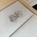 Detail view of silver square metal studs with unique ripple texture on beige fabric - Silver Square With Steel Pin