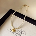 Elegant pearl necklace with a vintage gold lotus fan pendant and metallic accents - Pearl Gold Fortune Bag Style