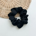 Detailed view of large black matte satin scrunchie with soft fabric pleats - M Black