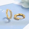 Makro-Detail von goldenen Creolen mit Zirkonia und S925-Silber-Prägestempel-Prüfung - Kupfer / Gold Weiß Zirkonia