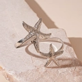 Detail of silver starfish arm cuff with textured surface on natural stone background - Silver Starfish Textured Open Arm Cuff