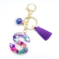 Letter S resin keychain with purple tassel and colorful stone chips on golden ring - S