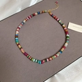 Macro view of multi-color disk beads necklace with gold metal chain and teardrop pendant - Gold Multi-color Beaded Necklace / Colorful