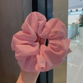 Pink oversized chiffon scrunchie with pleated texture held in hand for volume display - Pink