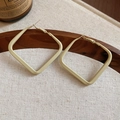 Close-up of cream square geometric hoop earrings on a rustic wooden tray background - Cream Color Square Loop