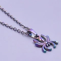 Macro detail of a spider pendant necklace with a vibrant iridescent rainbow metallic finish - Necklace / Rainbow