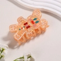 Macro view of gingerbread man hair claw clip with amber glitter and holiday patterns - Gingerbread Man 1
