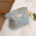 Detail of floral makeup bag with blue and pink patterns on white linen background - Pink and Blue Floral